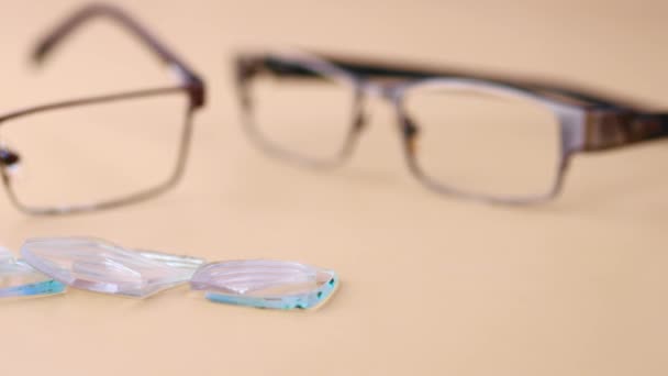 Gafas con cristales rotos en la mesa — Vídeo de stock