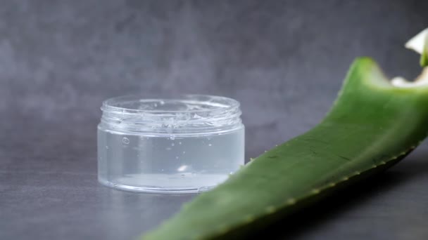 Aloe vera fresco em fatias e gel líquido em recipiente de plástico sobre fundo branco — Vídeo de Stock