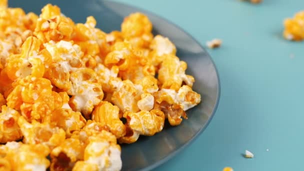 Smaczny karmelowy popcorn na talerzu na stole — Wideo stockowe
