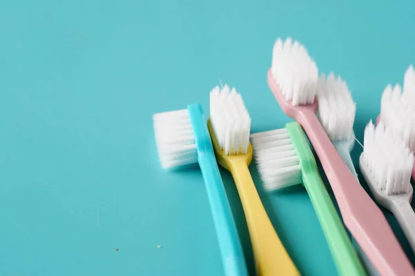 Colorful toothbrushes on light green background — Stock Photo, Image