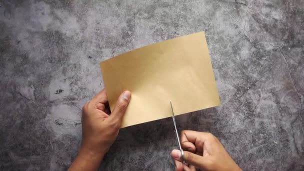 Vista superior dos homens mão cortando um papel em branco na mesa — Vídeo de Stock