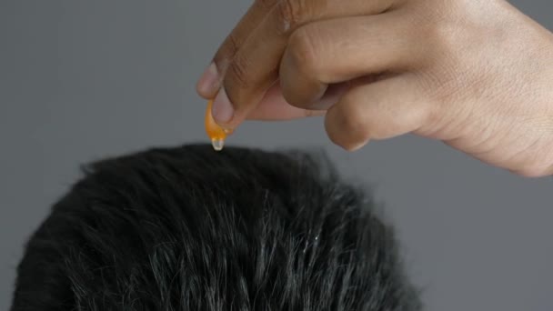 Muži aplikující kapsle olej na vlasy — Stock video