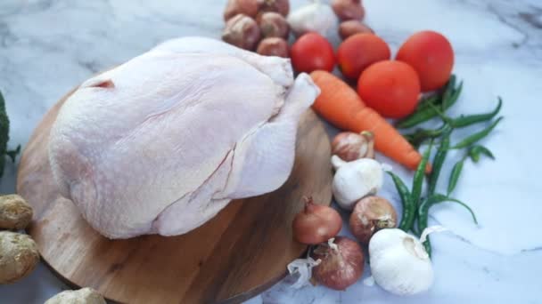 Ωμό ολόκληρο κοτόπουλο και λαχανικά σε πλακάκια φόντο — Αρχείο Βίντεο