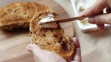 Masadaki ekmeğe sürülmüş peynir kremi.
