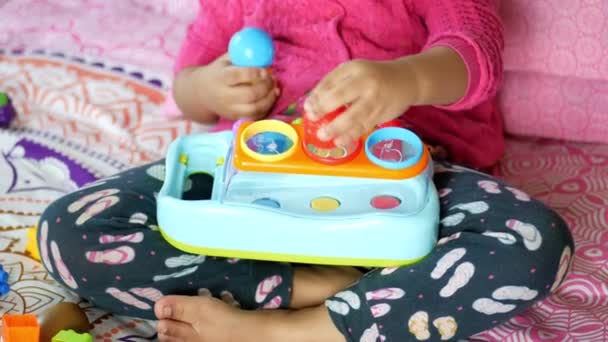 Niña jugando con juguetes en la cama — Vídeos de Stock