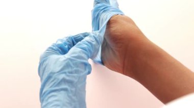 Doktor tıbbi lateks eldiven takıyor, yakın çekim.