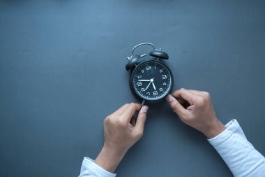  Alarm saatini tutan kişi siyah arkaplan ,