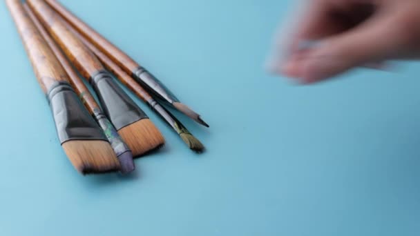 Children hand pick a art brush on light green background — стоковое видео