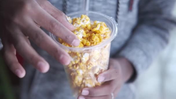 Widok z góry dziecko dziewczyna ręka gospodarstwa miska kolorowy popcorn — Wideo stockowe