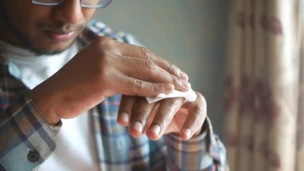 Człowiek dezynfekujący ręce mokrą chusteczką. — Wideo stockowe
