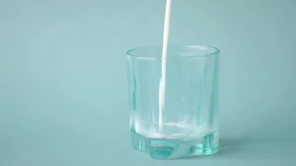 Αργή κίνηση της χύτευσης γάλακτος στο ποτήρι στο τραπέζι — Αρχείο Βίντεο