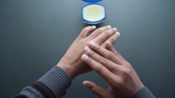 Fechar a mão do homem usando vaselina contra fundo preto — Vídeo de Stock