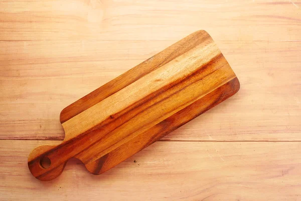 Tagliere in legno su sfondo in legno top down — Foto Stock