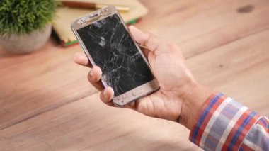 Kırık akıllı telefonu tutan adama yakın dur..