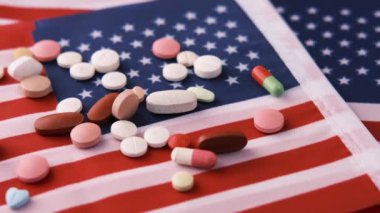  Amerikan bayrağına beyaz renkli tıbbi haplar dökülüyor. 