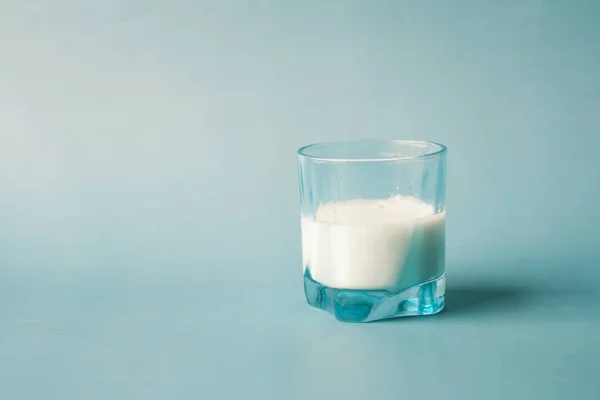 거품이 나는 배경에 우유 한 잔을 덮어 놓음 — 스톡 사진