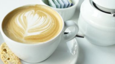 Kafenin tepesinde çiçek desenli geç kalmış bir fincan kahve. 
