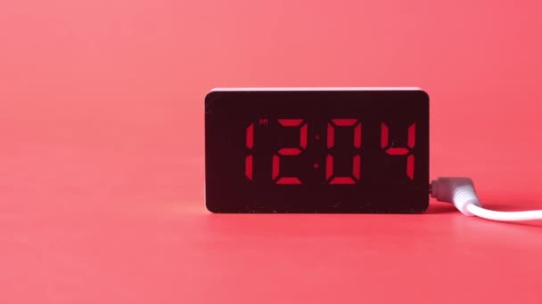 Reloj digital sobre fondo rojo de cerca — Vídeo de stock