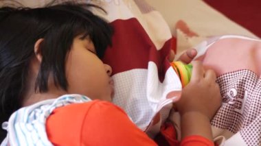 4 yaşında bir kız çocuğu yatakta uyuyor. 