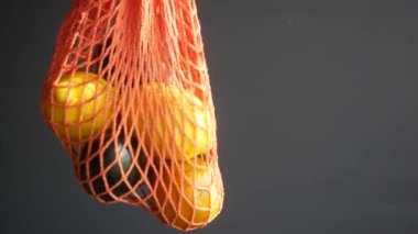  Taze portakal ve avokado, siyah arka planda bir alışveriş torbasında. 