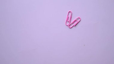 Pembe arka plana renkli ataç düşüyor .