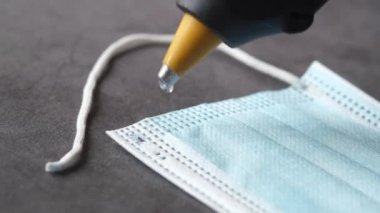  Onu onarmak için mavi ameliyat maskelerine yapıştırıcı sürüyorum. 