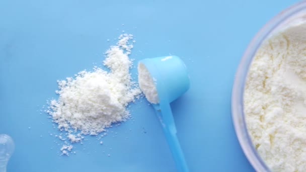 Κοντινό πλάνο του βρεφικού γάλακτος σε σκόνη και κουτάλι στο φόντο πλακιδίων. — Αρχείο Βίντεο