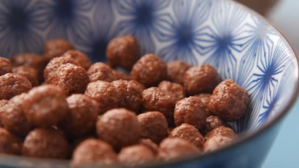 Close-up van chocolade cornflakes in een kom op tafel — Stockvideo