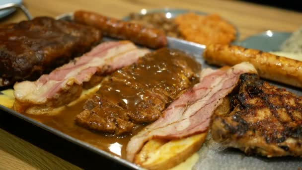 Gorące steki wołowe mięso na talerzu na stole — Wideo stockowe