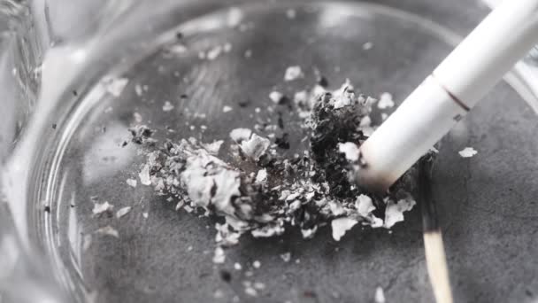 Chiudere bruciando sigaretta nel posacenere sul tavolo — Video Stock