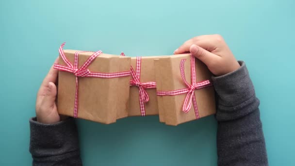 Niño mano celebrar caja de regalo casera contra fondo verde claro — Vídeos de Stock