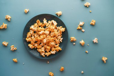  Tahta masadaki kasede patlamış mısır.