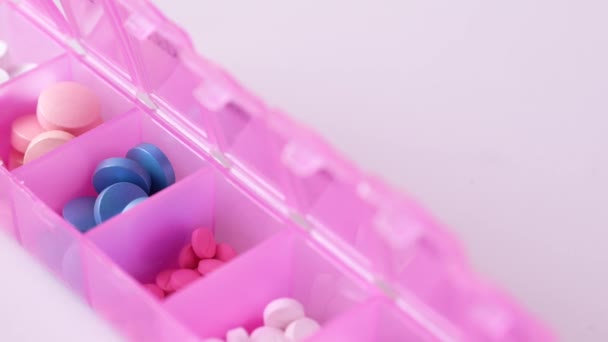 Primer plano de las píldoras médicas en una píldora color caja de la píldora — Vídeo de stock