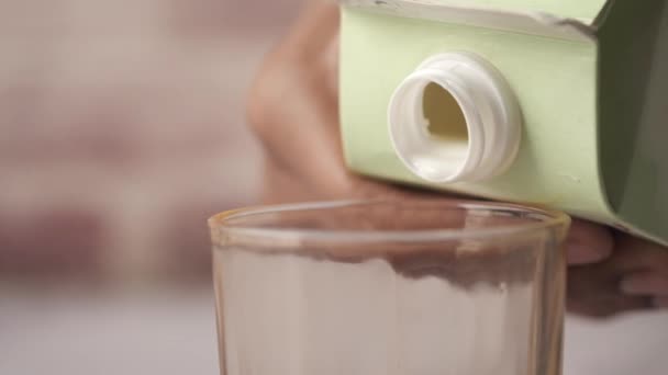 Verter la leche en el vaso sobre la mesa — Vídeo de stock