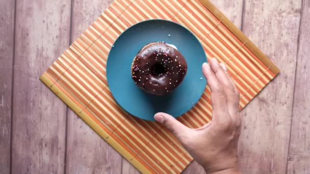 Joven que busca una rosquilla fresca en la mesa — Vídeos de Stock