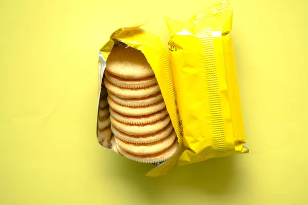 Perto de biscoitos de queijo em um empacotador amarelo na mesa — Fotografia de Stock