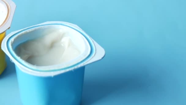 Verse yoghurt in een gele en blauwe plastic container voor kind — Stockvideo