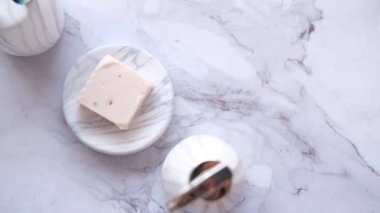 Beyaz fincanda diş fırçalarının üst görünümü ve fayans zemininde sabun 