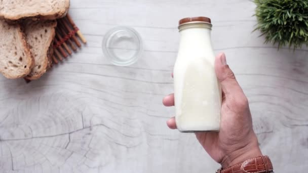 Χέρι κρατώντας ένα δοχείο γάλακτος πάνω όψη — Αρχείο Βίντεο