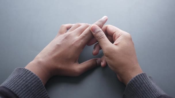 Человек, страдающий от боли в пальце на черном фоне — стоковое видео