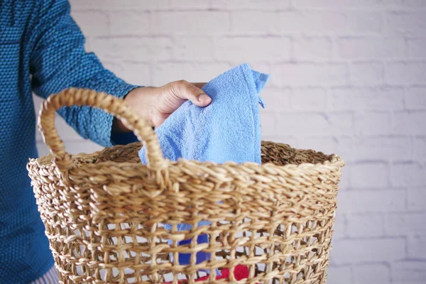 Jongeman gooit kleren in mand op vloer — Stockfoto