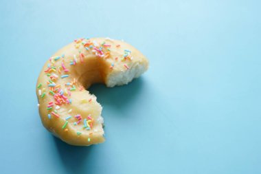  Mavi arka planda yarısı yenmiş çörekler 