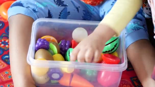 Niña jugando con juguetes en la cama — Vídeo de stock