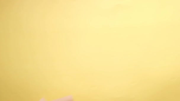 Slow motion av tomt papper släppa på gul bakgrund — Stockvideo