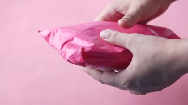 Pembe renkli teslimat paketini tutan kadınlar. — Stok video