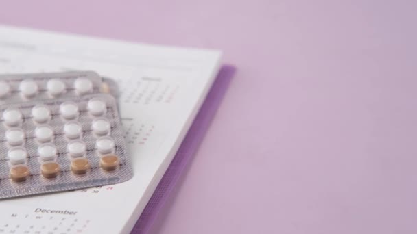 Pilules contraceptives, calendrier et bloc-notes sur la table — Video