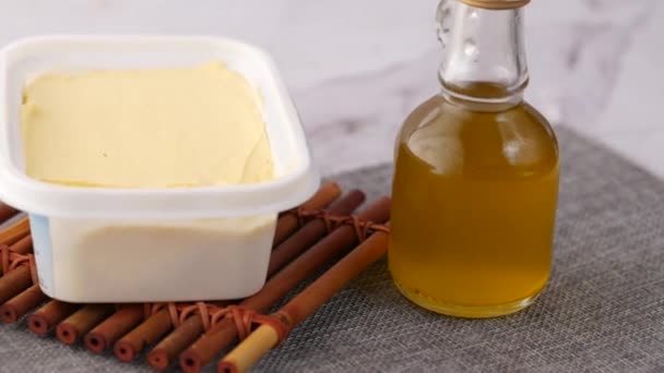 Beurre frais dans un récipient avec du pain sur fond blanc — Video