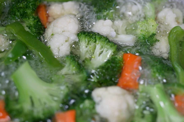 Cozinhar salada de legumes frescos em uma água quente — Fotografia de Stock