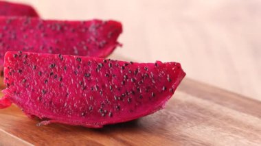 Bir dilim ejderha meyvesi doğrama tahtasında.