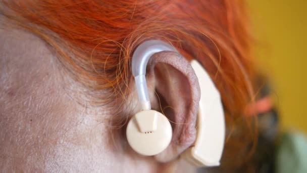 Η έννοια του βοηθήματος ακοής, μια ηλικιωμένη γυναίκα με προβλήματα ακοής. — Αρχείο Βίντεο